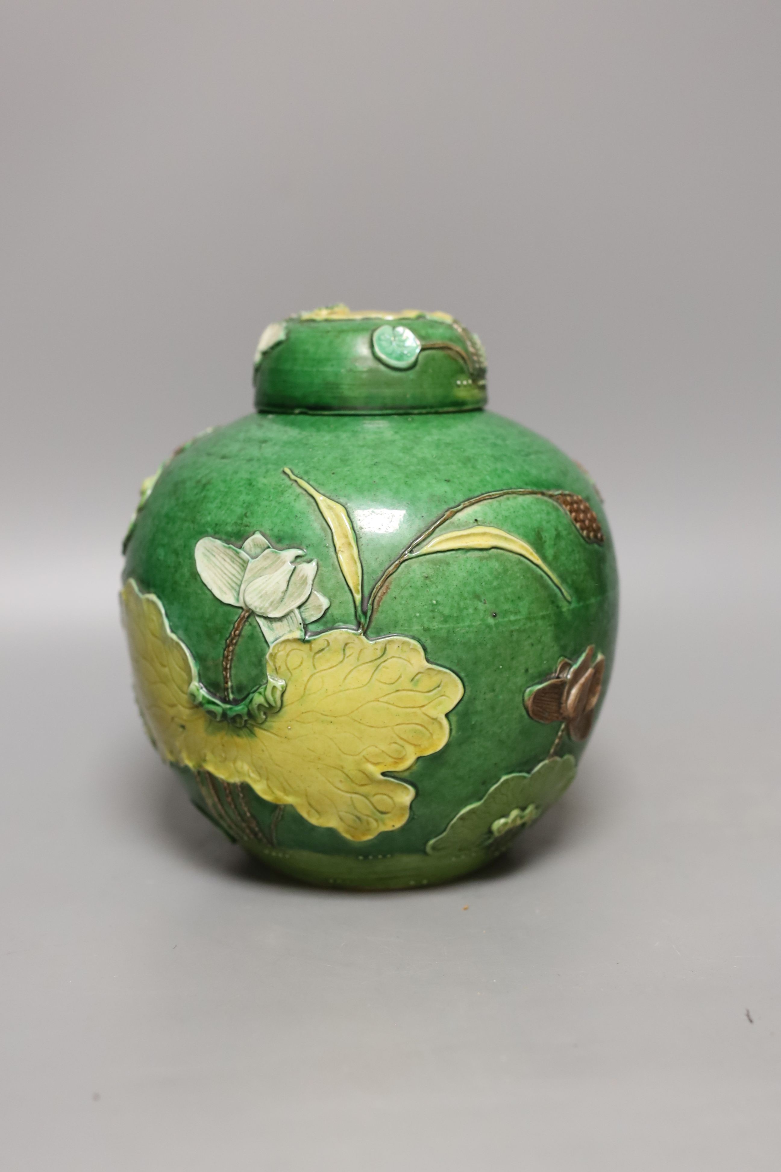 An early 20th century Chinese green-glazed ‘lotus’ jar and cover 18cm